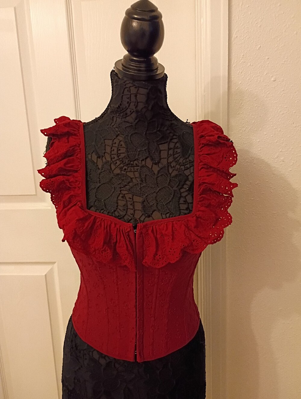 Burgundy sleeveless corset-style top features a square neckline.